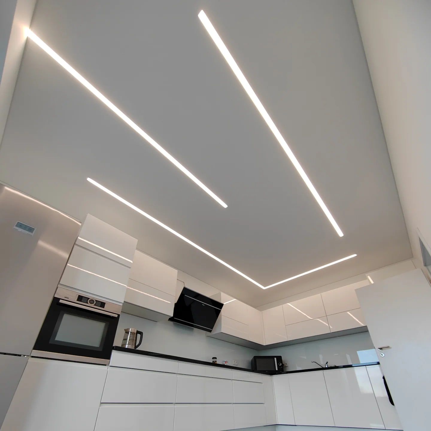 Küche: Weiße Spanndecke mit parallel geführten Lichtlinien.